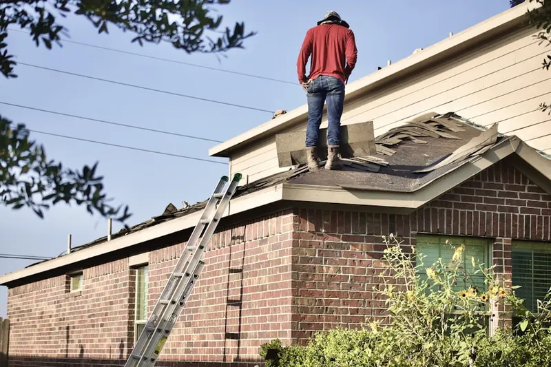 Professional roofer working on a residential roof in Powerville